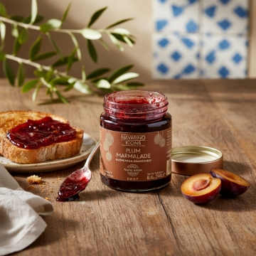 Artisanal Greek Plum Jam on Toast | Navarino Icons Daily A rustic Greek breakfast table with Navarino Icons Plum Marmalade on toasted bread, fresh plums, and an olive branch, highlighting its artisanal quality